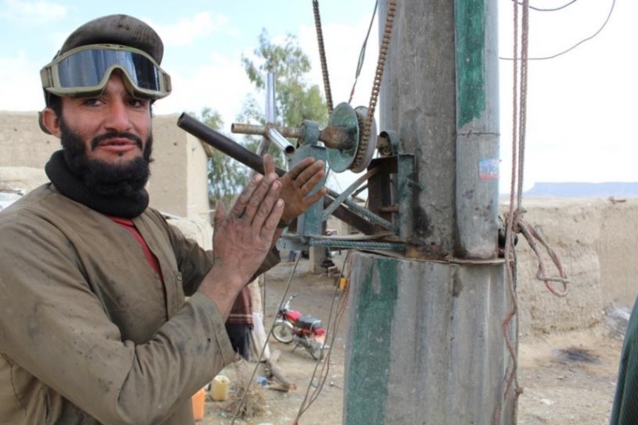 Abdul Jameel, the owner of a wielding micro-business supported under the ABADEI programme, turns the solar panels toward the sun to generate electricity in Kandahar province. Photo // DRC