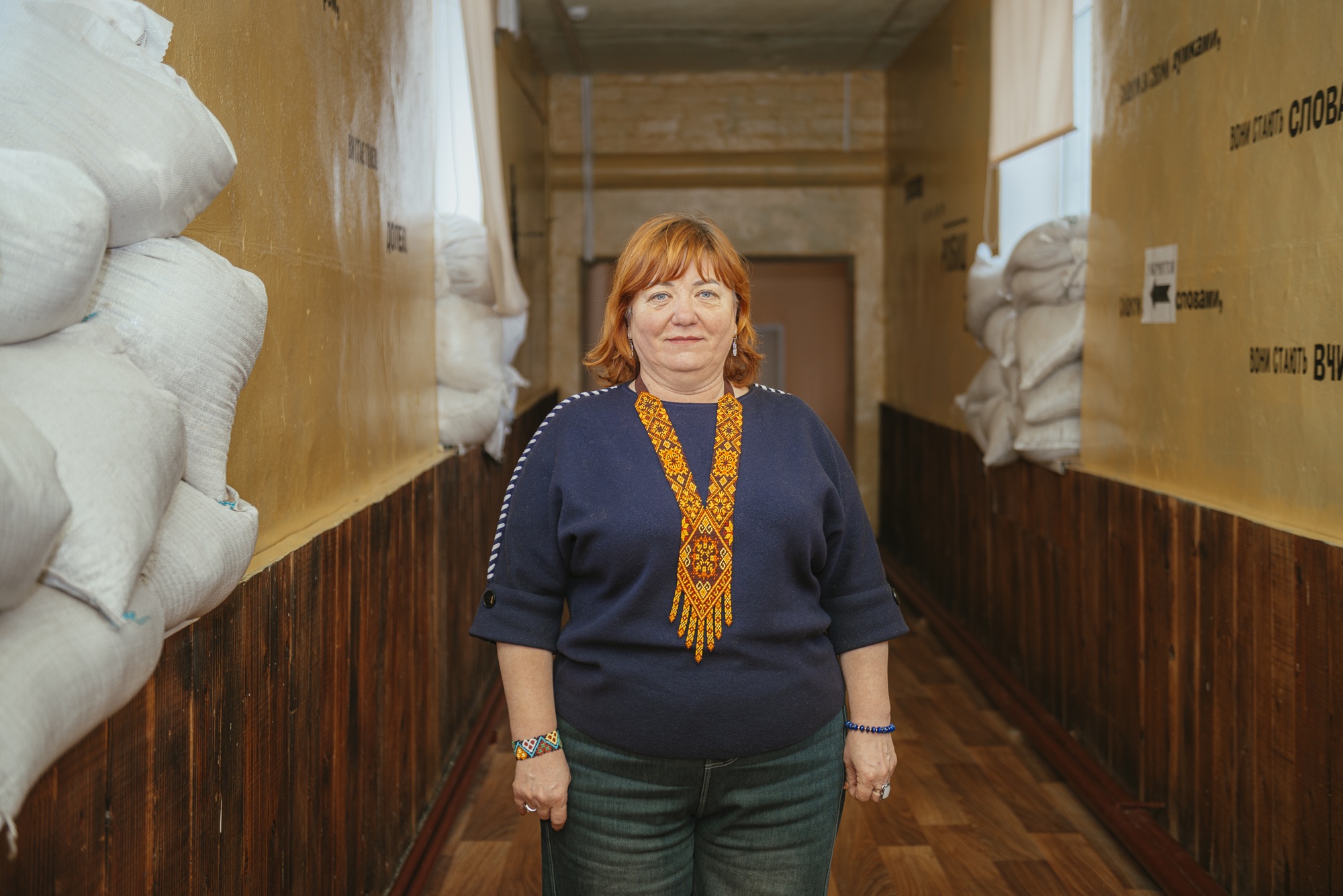 Olha Kis, Deputy Head of the Bilenkivska Hromada Village Council, standing in a school corridor. ©DRC Ukraine, Zaporizhzhia Oblast, 2026, Krystyna Pashkina.