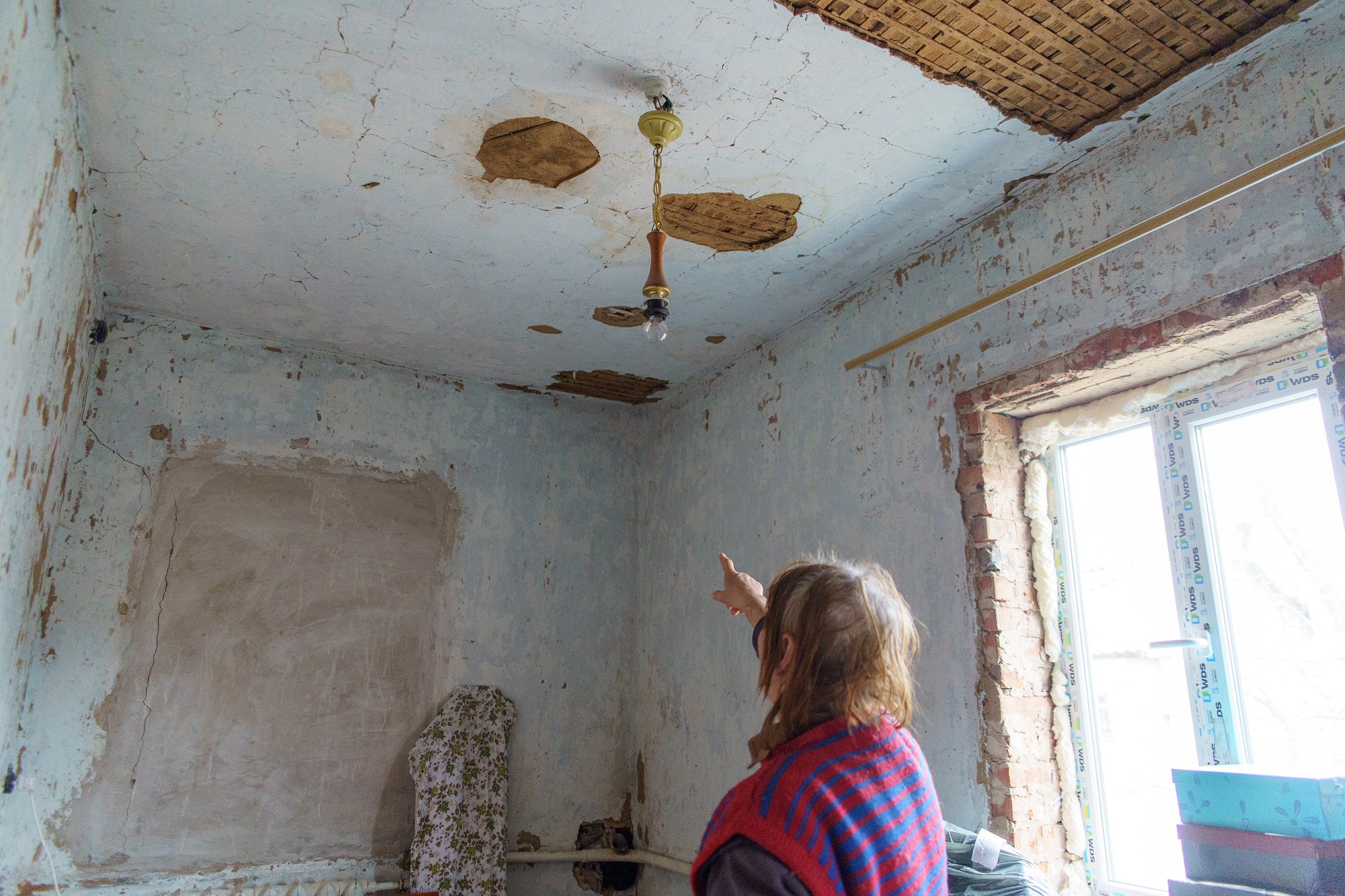 Larysa shows the damage to her house in Kyinka hromada caused by shelling. ©DRC Ukraine, Chernihiv oblast, 2023, Volodymyr Cheppel.