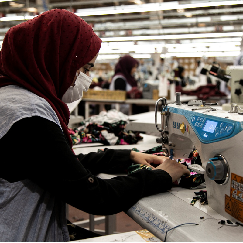 A participant of DRC Türkiye’s Wage Subsidy scheme in Şanlıurfa is at her workstation in a local garment factory. The programme supports both refugee and host community members in accessing formal employment.