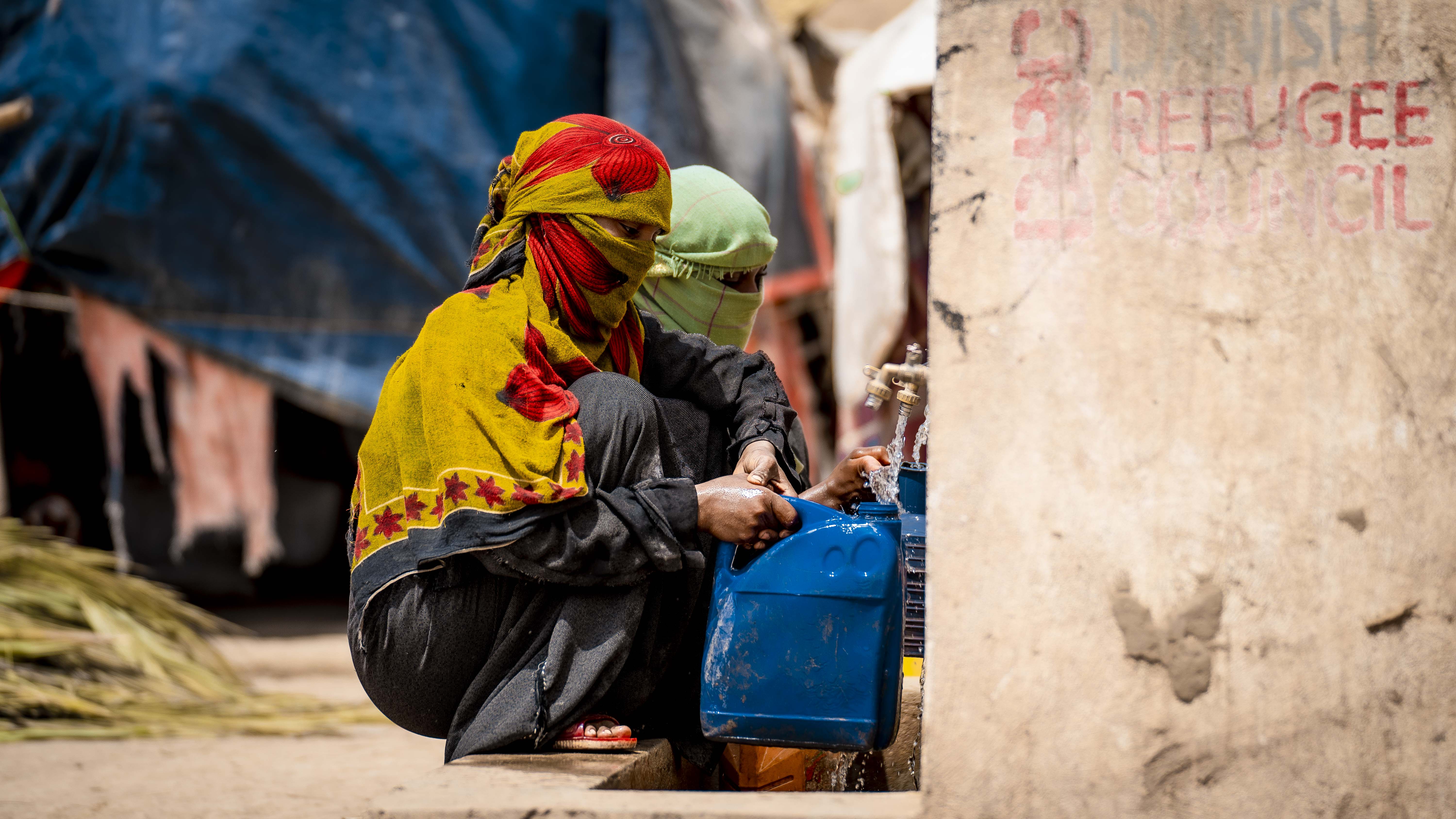 Displaced women carrying after accessing water from the water point in Al Husseini camp, Tuban district, Lahj governorate. Abdullah Al Keldy
