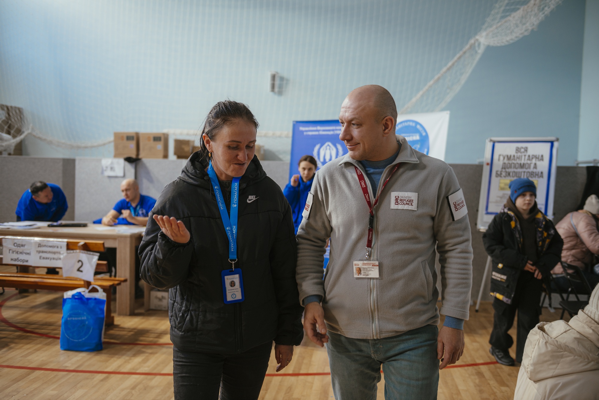 Alina, the Transit Centre Administrator, discusses further support with Ihor, DRC Partnership Officer, in the centre’s reception space. ©DRC Ukraine, Dnipropetrovsk  Oblast, 2026, Krystyna Pashkina.